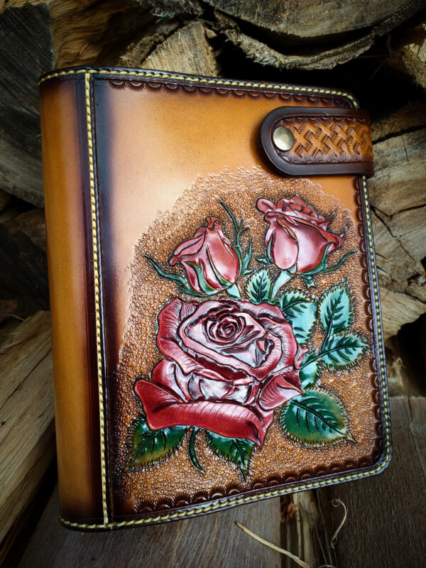 Portada de funda de cuero con rosas rojas repujadas.