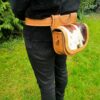 Bolso de piel de vaca colgado en el cinturón.